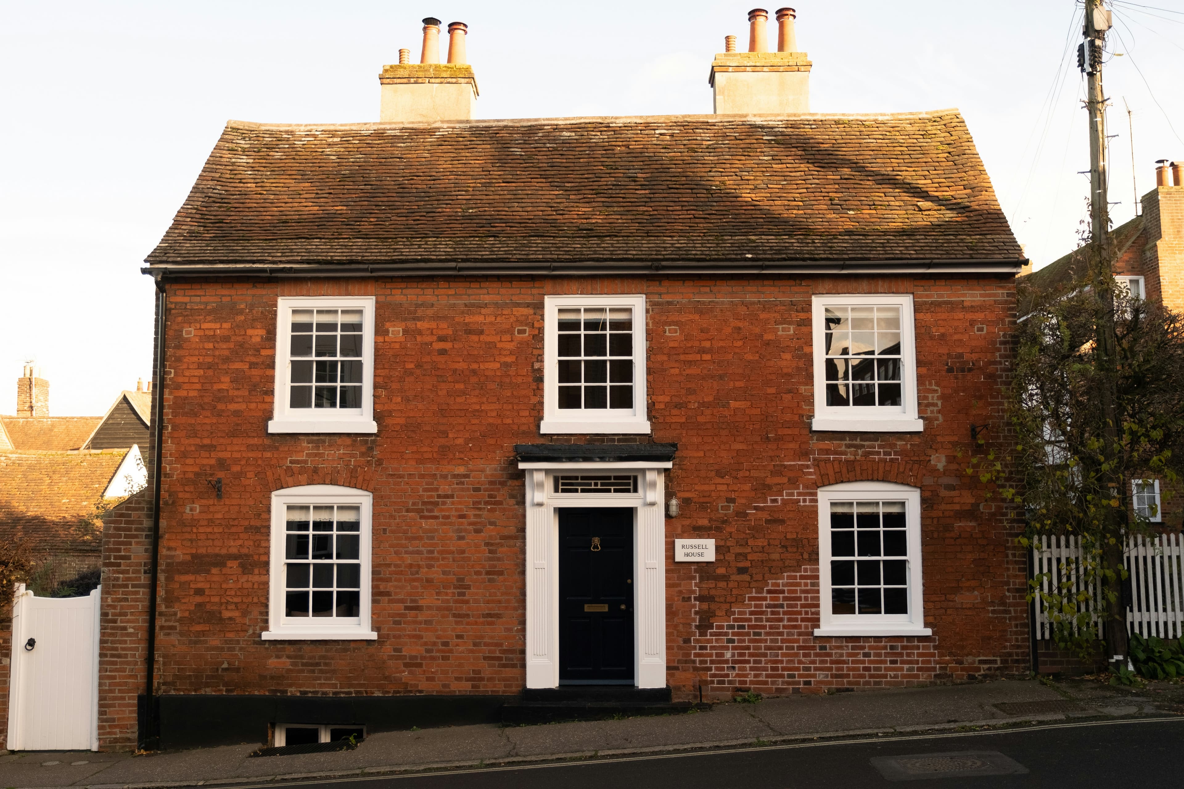 The front of a red brick family home with a black front door